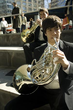 MUSIC TO MY EARS: Junior Tim Vazquez practices his french horn on the steps outside of Alice Tully Hall. Due to a lack of rehearsal space for the orchestras over 130 members, students chose to practice outside where New Yorkers stopped and observed the spectacle.