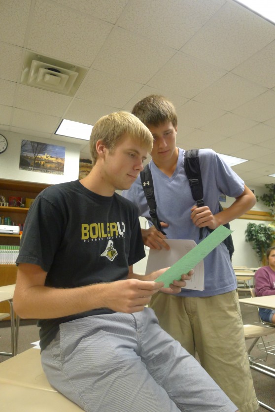 Senior Brad Kremer  (left) and senior Elliot Browning (right) check  the DECA schedule for officer election dates.  Any DECA member, like Kremer, will be eligible  to run for office. SARAH YUN / PHOTO