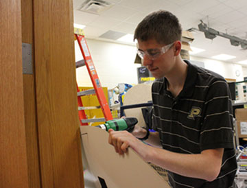 DRILL, BABY, DRILL: Ryan Wilmes, TechHOUNDS student team leader and senior, works on a sign for a new TechHOUNDS project. According to Wilmes, the team’s current priority is training all new members. PHOTO / MELINDA SONG