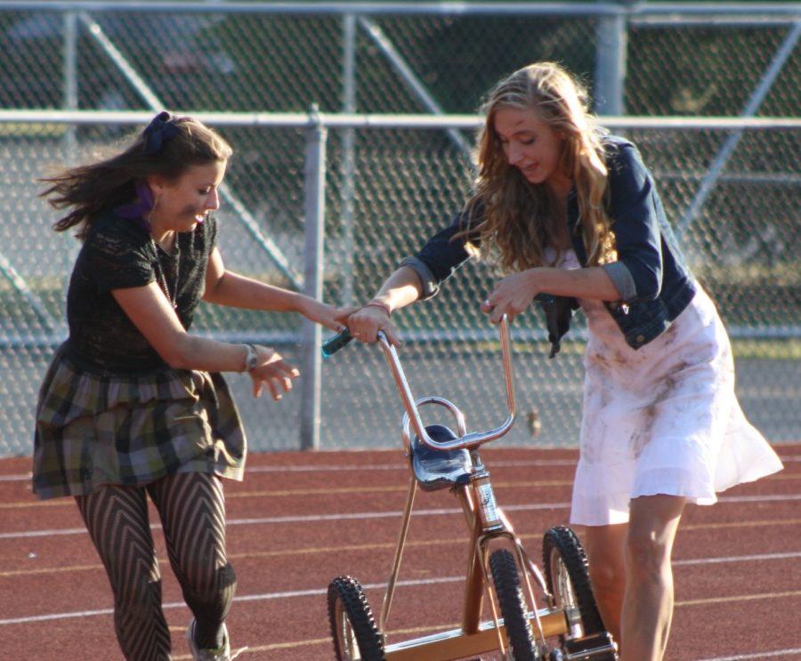 HAND IT OFF: Juniors Megan Ernst and Ellen Schnmitz make an exchange during the trike race preliminaries on Sept. 15. The trike race finals took place on Sept. 16 at the stadium as part of Homecoming festivities where The Goodwilligans won. MARY BROOKE JOHNSON / PHOTO
