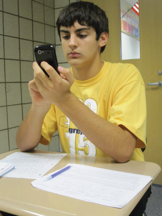 Freshman Colby Cronnin checks his smartphone while doing homework. Cronnin said he has started obsessively checking his cell phone, even while he is studying. KATHLEEN BERTSCH / PHOTO