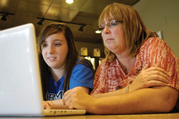 STUDENT BECOMES THE TEACHER: Junior Dana James teaches her mother some basic actions on Facebook. “Basically,” said James, “I just have to show Mom the ropes, and occasionally, I have to show her something new, but otherwise, she’s a fast learner. She knows her way around the site.” GAVIN COLAVITO / PHOTO