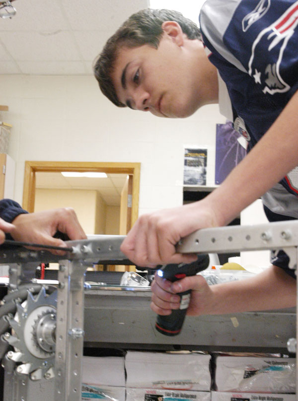 Norman Noe, robot ops division lead and senior, works on assembling a Mecanum drive train during SRT. According to Noe, the TechHOUNDS team will build three drive trains during its pre-season. MELINDA SONG / PHOTO