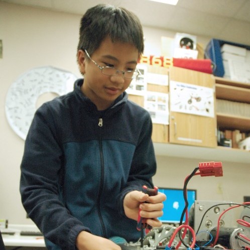 Sophomore Joshua Chang places finishing touches on the Mecanum model drive train for the robot ops division of TechHOUNDS in SRT. According to club sponsor George Giltner, the robot ops team was successful in completing its goal of building three drive trains during the pre-season. MELINDA SONG / PHOTO
