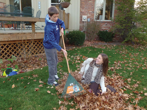 Family time: Senior Julia Valente and Matthew Sheek, host brother and freshman, rake leaves from the yard. Valente, who has adjusted to life in Carmel, said chores are an adjustment that she has had to make between life in Carmel and life in Brazil.