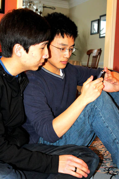 PLAY ON: Michael Wang, mobile video gamer and senior, and junior Nick Shi play a game on Wang’s iPhone. Wang said he likes mobile gaming more than playing with a gaming console. SHEEN ZHENG / PHOTO