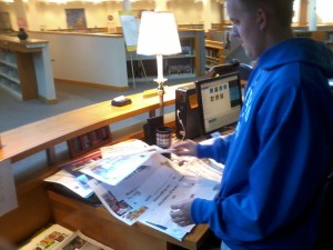 Freshman Kevin Martin helps sort the promotion posters for the Have a Heart amnesty. The amnesty, which will run from Feb. 21 to March 9, clears students library overdue fines when they bring in canned foods or toiletries. PHOTO / DAVID CHOE