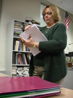 English teacher Michele Satchwell hands out packets to her advanced composition class. Satchwell said she is uncertain about the objectivity of the RISE teacher effectiveness rubric. LAURA PENG / PHOTO
