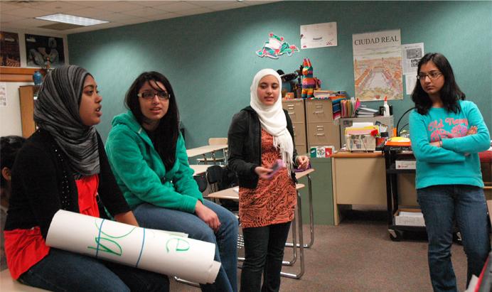 Leena Mossa-Basha (second from the right), Free Syria advocate and junior, talks with the Muslim Student Association (MSA). The MSA hosted a bake sale starting April 16 to raise money for aid. MIKAELA GEORGE / PHOTO