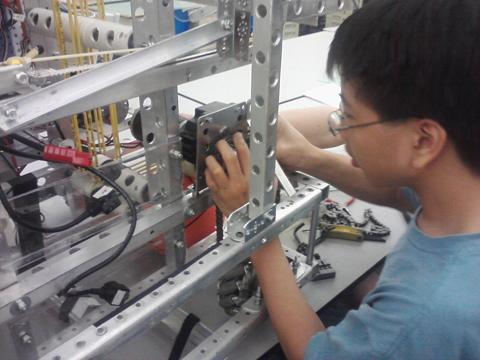 Joshua Chang, two-year TechHOUNDS member and sophomore, makes modifications to the robot during SRT. Chang said he hopes to return to the team next year. MELINDA SONG / PHOTO