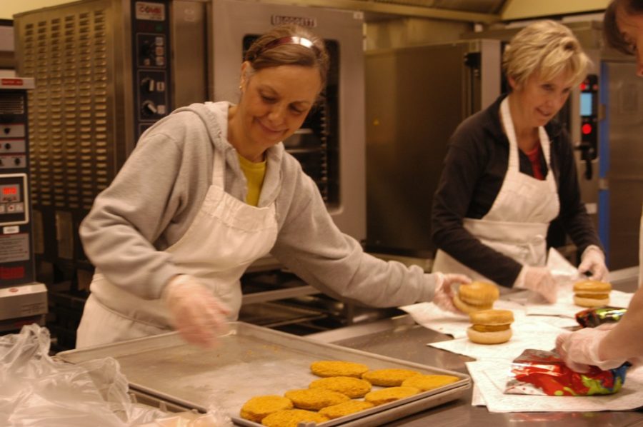 Cafeteria workers make chicken sandwiches. Full lunches now include an entree, drink, vegetables and fruit. MEYER / PHOTO