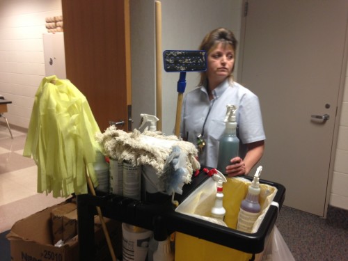 Custodian Susie Denson searchs her cart for cleaning supplies in the E hallway. Assistant principal Doug Bird said the maintenance and custodial departments are preparing for any severe weather, in addition to their regular duties. CLAUDIA HUANG / PHOTO