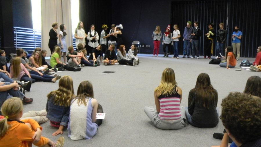 Members of Rising Stars sit in a circle as the listen to the directions for a game. Members play acting games often because they are fun and can help to improve technique. AINING WANG / PHOTO