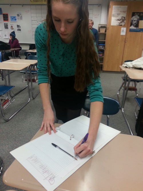 Anna Bouillet, club member and sophomore, signs in during a meeting. Creative Writing Club meetings are held in Room E148 every Tuesday. NIDA KHAN / PHTO