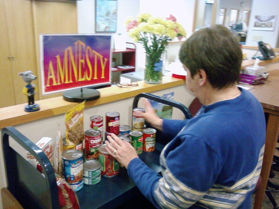 Media manager Donna Prather sorts through the donated cans for the Food For Fines amnesty. Prather said although students have participated, more need to donate and participate in the opportunity to clear library fines. DAVID CHOE / PHOTO
