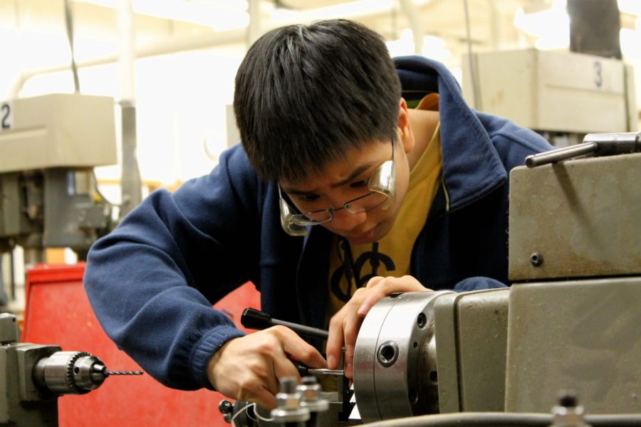 Junior Joshua Josh Chang works with machinery in the engineering department. In their work, TechHOUNDS utilize the 3-D printer, which makes production easy and cheap while also raising several copyright and patent questions.