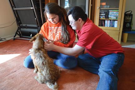Senior Michael Sharkey pets the household dog with his sister. Sophomore Samantha Sharkey said her brother has changed her life for the better in many ways. HAILEY MEYER / PHOTO