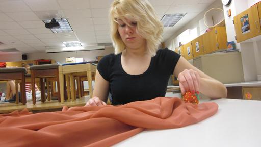 Senior Jill Nobis works with a fabric during fashion class. According to The New York Times, Pantone assigns a certain color as the color of the year, which fashion designers like Nobis use as inspiration in their designs. JENNA RUHAYEL / PHOTO