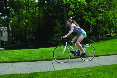 Sophomore Diana Gorin rides her bike on a local bike path. Legislators are drawing up a plan to cut back on new bike paths which would affect the safety of bike riders. HEEJUNG KIM / PHOTO