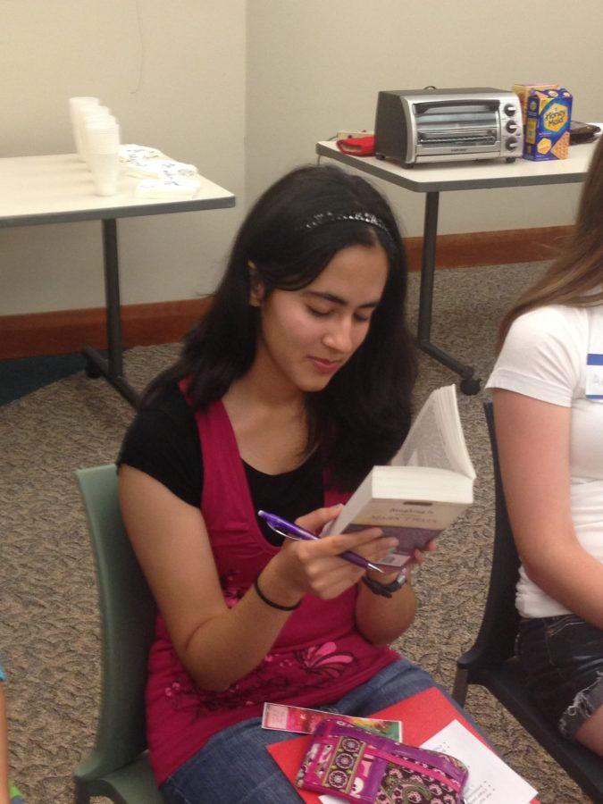 Sophomore Kimaya Raje reads her book at the TLC meeting. Many TLC members like Raje said they were eager to begin a new year with the TLC . RUSHI PATEL / PHOTO
