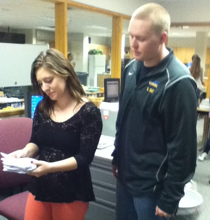 Emily Levine and Brandon Cole, DECA members and seniors, examine newly-made fliers for Holiday Secret Shop. DECA members will promote the Holiday Secret Shop in many other ways as well, including by advertising in various Carmel area publications like the Current in Carmel. CHRISHAN FERNANDO / PHOTO