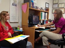 Counselor Stephanie Payne meets with a senior about her college applications. Payne said many applications for scholarships, early decision or early action are due Nov. 1. NAOMI REIBOLD / PHOTO