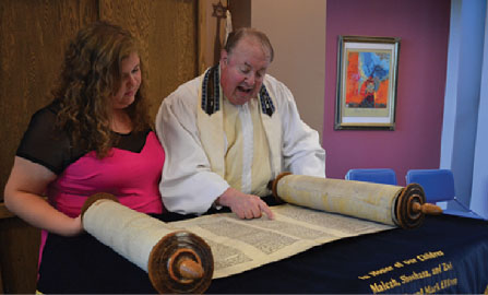 Junior Rachel Sendrow and her father, rabbi Benjamin Sendrow read the Torah at the Congregation Shaarey Tefilla. They plan to combine traditions of  both Thanksgiving and Hanukkah this year. NATALIA CHAUDHRY / PHOTO