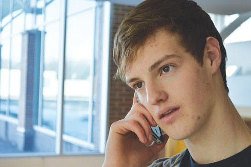 Sophomore Joe Philleo uses his cell phone. Although people can’t use cell phones for voice communications on airplanes, the new FAA regulations will allow people to use electronic devices for other purposes. ALEX YOM / PHOTO
