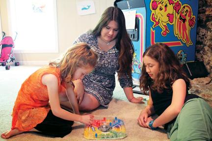 Junior Abby Fields plays a game of Trouble with Sydney (left) and Olivia White (right), two girls, she babysits. Fields said she wants to obtain a babysitting license, which will give her more freedom as a babysitter. NIVEDHA MEYYAPPAN / PHOTO