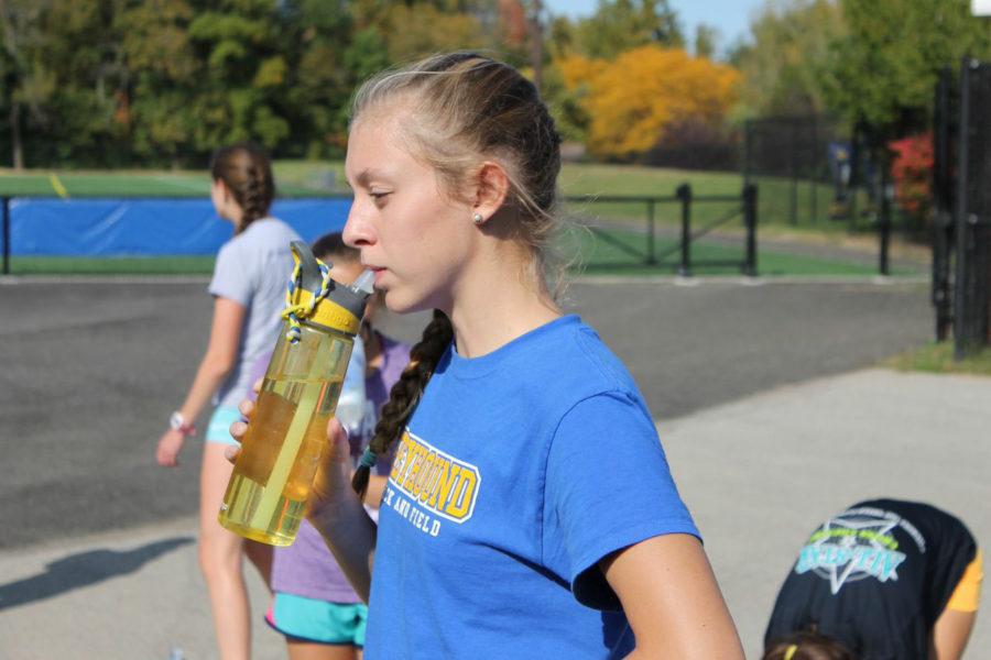 Senior Anna Schmitz takes a water break in practice. She will compete with the rest of the cross-country team in the Sectionals race conducted in Noblesville.  PHOTO / SARAH LIU