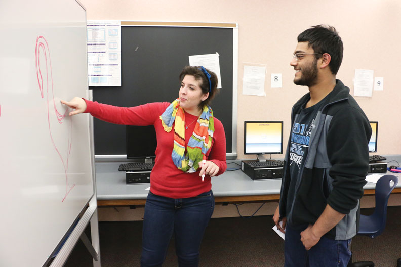 Mara Fattah, Design for CHS member and senior, discusses her Build-A-Bench designs with another member, junior Asif Hossain. Fattah said her design is inspired by birds, namely swans. DIVYA ANNAMALI / PHOTO