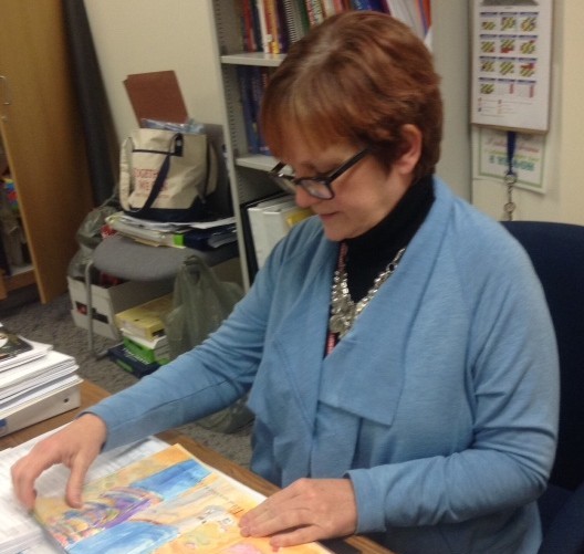 Kim Lenzo, director of Kids’ Corner, looks at a children’s book. Lenzo said the student teachers are currently working on preliminary planning. CYNTHIA YUE / PHOTO