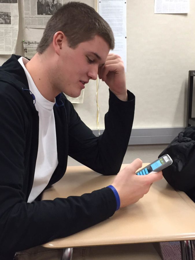 Senior Liam Duncan looks at his phone at the end of a government class. Duncan said he

would prefer adding on time to the end of school days like last year as opposed to adding Saturday school 

to make up for school cancellations. (PHOTO / MATTHEW DEL BUSTO)