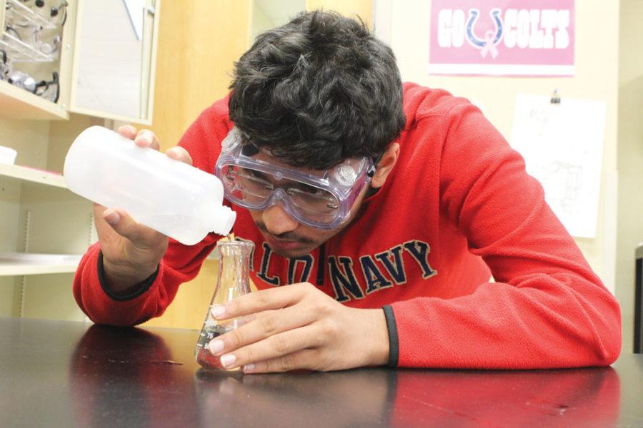 Freshman Rishi Das pours distilled water into a beaker during an experiment in AP Chemistry. Das said he plans to use his chemistry knowlege to help him in Project Lead the Way Biomedical Science next school year. ALLY RUSSELL / PHOTO