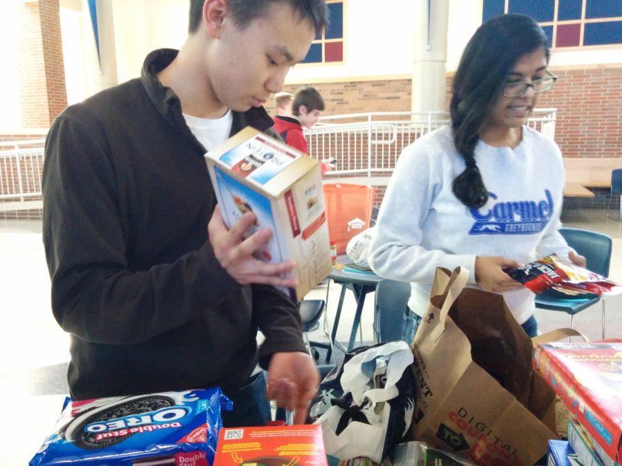 Natasha Crasta, Key Club vice president and senior, and Stone Chen, Key Club member and sophomore, sort non-perishable food at the Feb. 19 club meeting. The food was put into care packages to be sent to people in the U.S. military. MELISSA YAP / PHOTO