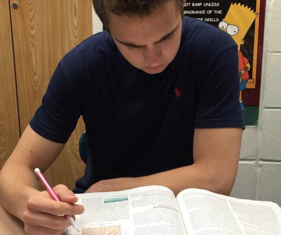 Matthew Keene, Senate member and senior, studies from his economics textbook during a break in AP English Language and Composition class. Keene said incorporating technology into school would have the benefit of enabling students to use technology responsibly. MATTHEW DEL BUSTO / PHOTO