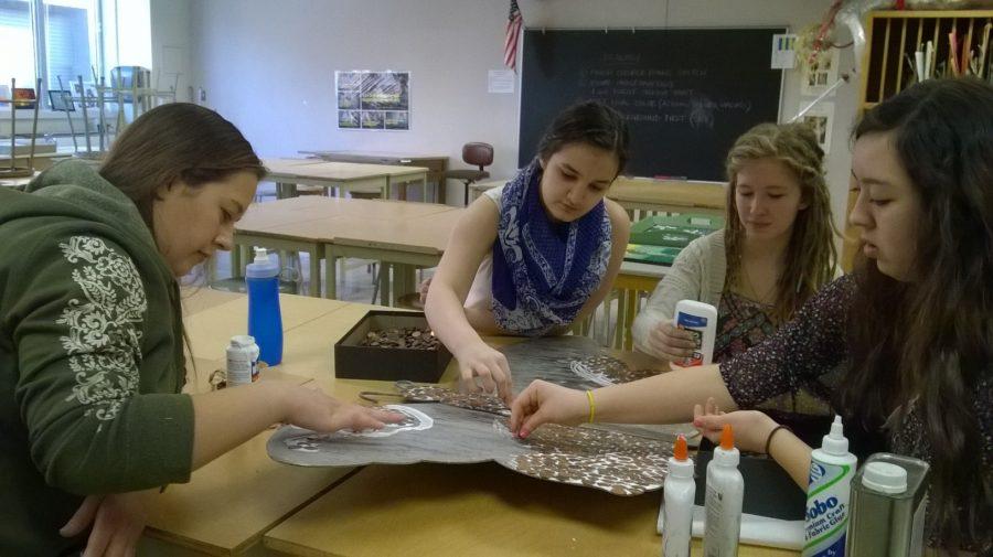 Art Club members glue pennies to the butterfly sculpture. Bubp said Art Club will install the sculpture in the Arts Garden upon completion. JESSICA MO/PHOTO