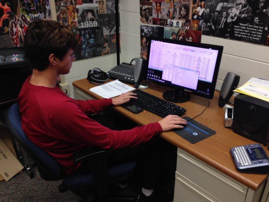 WHJE member and junior Zach Miller programs new songs into the radio stations database. Miller said he is focused on providing better-quality content for WHJE as well as the IASB radio competition in March. PHOTO/MATHEW ZHENG