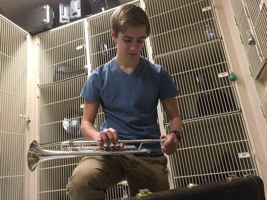 Alex Fleig, Jazz I Ensemble trumpet player and senior, assembles his trumpet in the band room. Fleig said he enjoys Jazz Ensemble because he likes the jazz style and the musical opportunities such as soloing. PHOTO/ KATIE LONG
