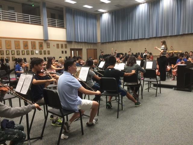 Sophia Tragesser, Symphony orchestra member and junior, warms up with the rest of the class during an exercise. Tragesser said she enjoys playing the violin and interacting with other sections.