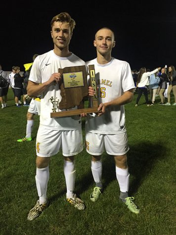 Senior Harrison Adams (left) and his brother, junior Cameron Adams (right), hold up the Sectional championship trophy after defeating Guerin Catholic High School. 