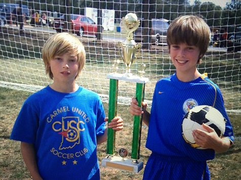 (TOP) Junior Cam Adams (left) poses with a trophy with his brother and senior Harrison Adams when they were 10 and 11 years old, respectively. This year, the Adams brothers played together for the first time. Harrison said, “We have a lot of fun together, we get to joke around, just mess around doing what brothers do, and playing on the same team as well.”