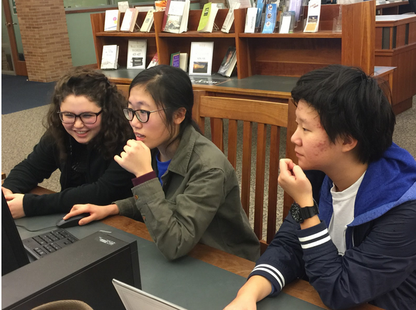Junior Catherine Yuan (far right), alongside sophomore Selin Oh (center) and junior Kiki Koniaris (far left) work on a project together at the Carmel Clay Public Library. According to Yuan, most of the people who attended top 3 percent last school year were involved in a wide array of activities and this portrays the emphasis on both school and extracurriculars from both the PTO and CHS.