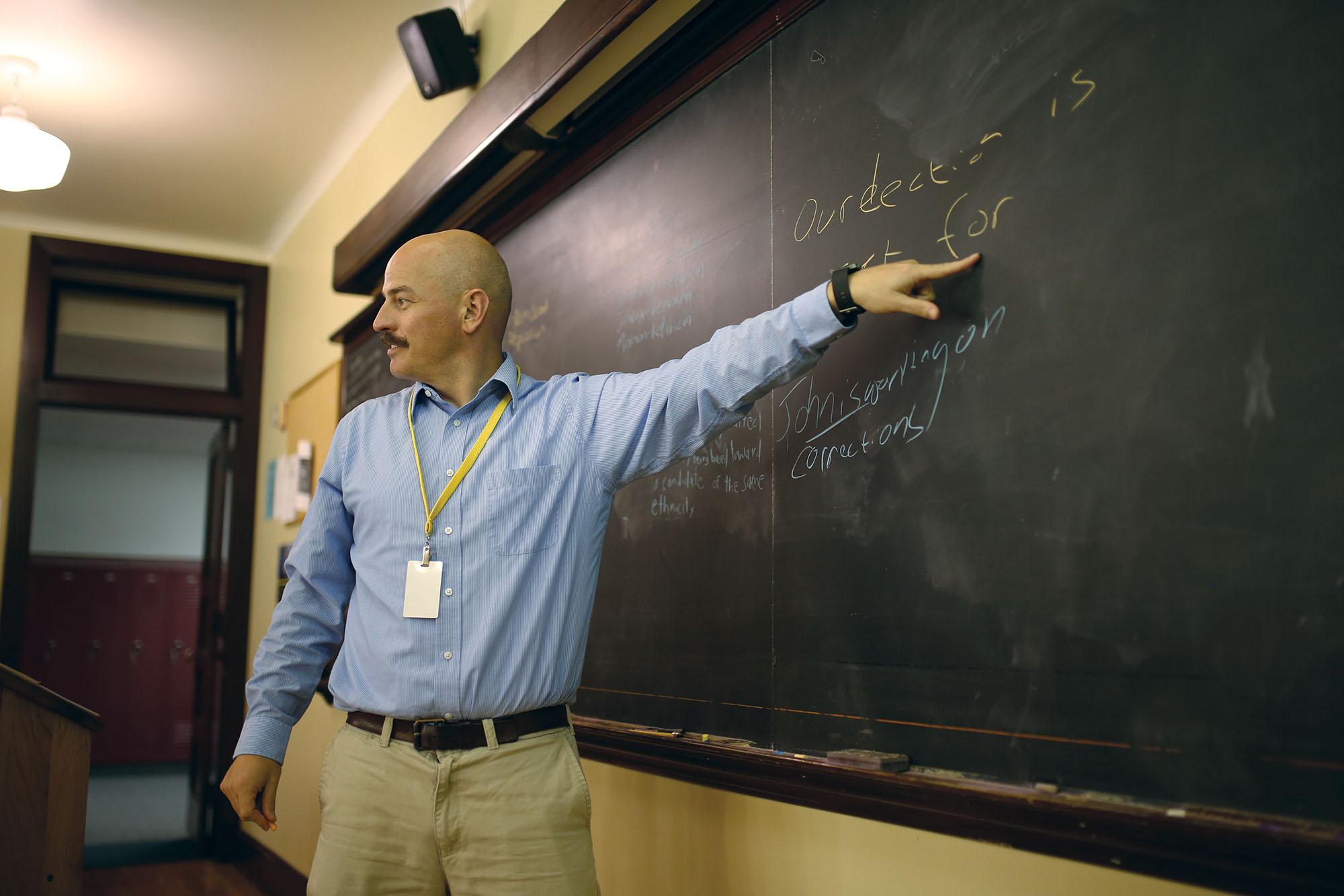 THIRD-PARTY THINKING: Government teacher Joshua Miller gestures toward his classroom’s blackboard. Miller said there were too many obstacles for third-party candidates in U.S. elections.
