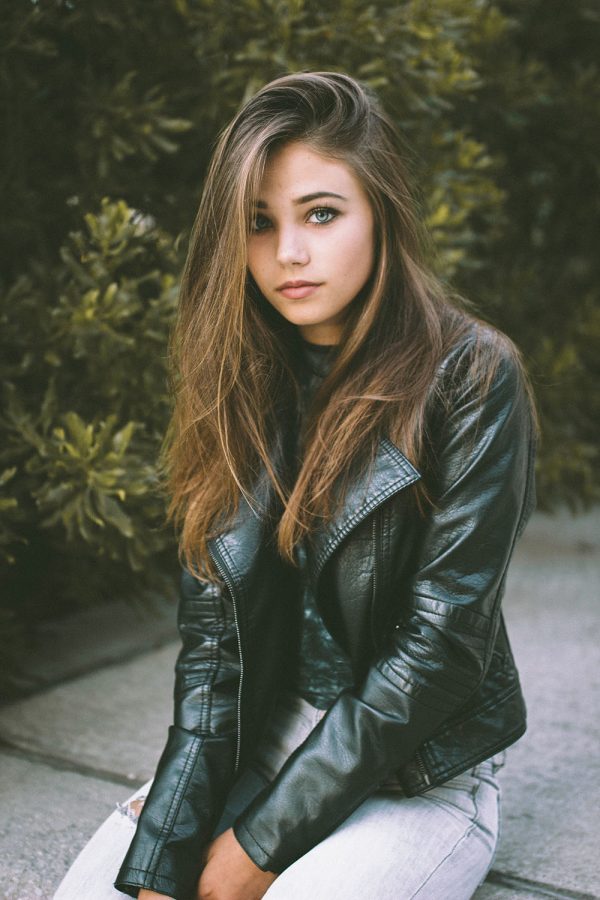 Model and junior Claire Estabrook poses in front of a forest background. Estabrook began modeling when Helen Wells personally asked her to sign and model for her agency.