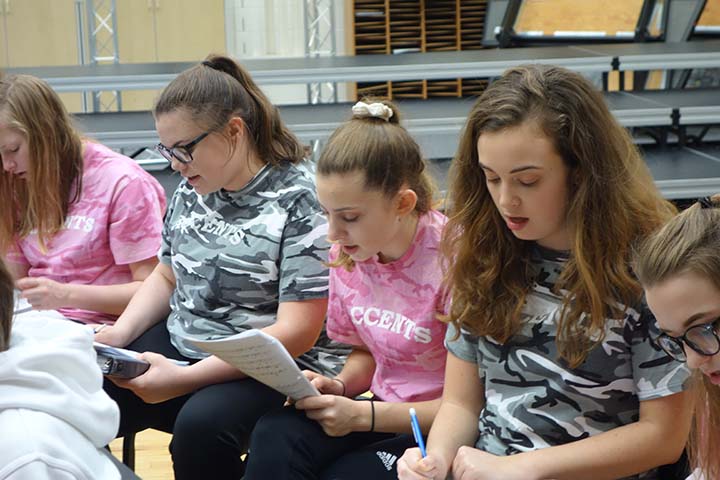 Laney McNamar (center) reads the notes to the song “Flashlight” by Jessie J with her fellow Accents. The song will be included in one of the five medleys in the group’s competition set this year.