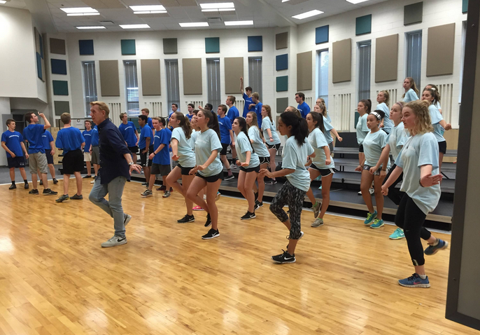 The Ambassadors practice their choreography in front of a mirror during afterschool rehearsal. Practicing in front of a mirror helps members match movements with each other.