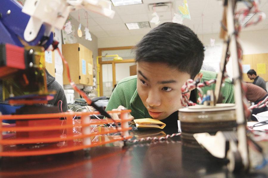 Senior Darren Chang checks a Robot Arm during a Science Olympiad meeting. The Robot Arm is one of the build events in competitions.