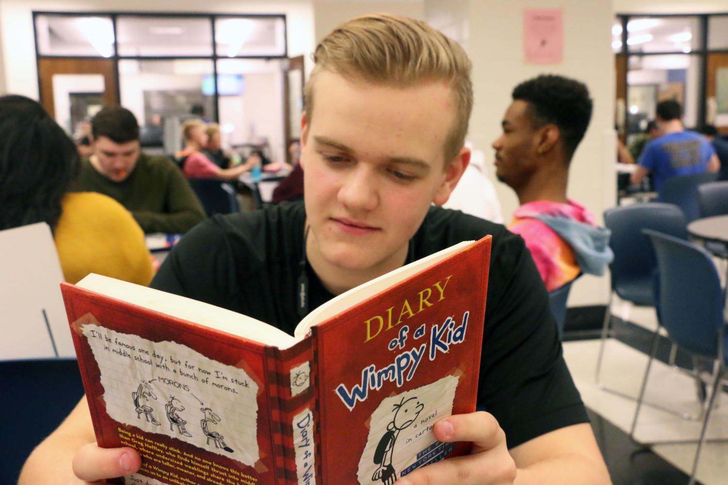 Sophomore Seth McLean reads a page from the first book of the Diary of a Wimpy Kid series. McLean said he did not like the change in actors for the character Rodrick in the movies.