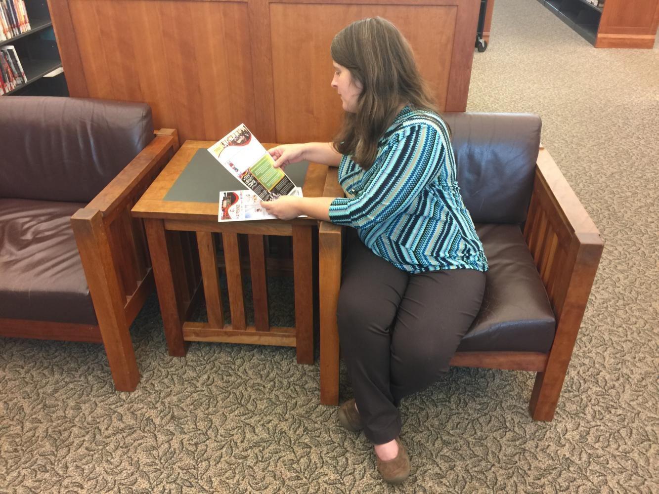 Jamie Beckman, Young Adult Section Librarian, corrects a flyer for the library’s events. The volunteering applications for the library are now open.